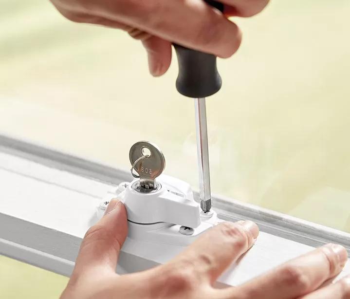 Trinco simples sendo instalado em uma janela por uma pessoa